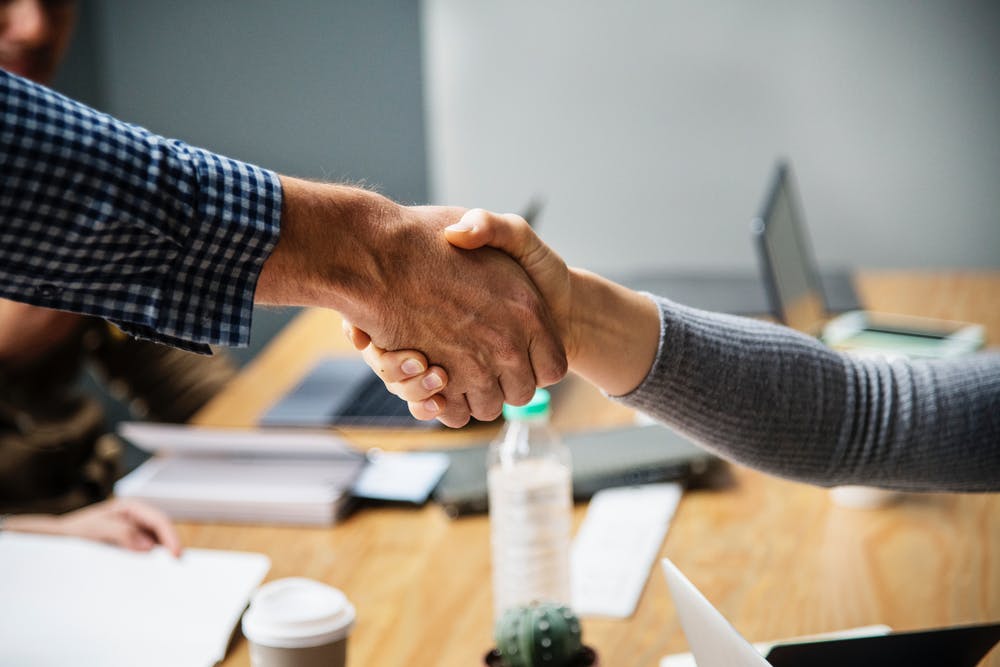 handshake over a desk - trust in food business